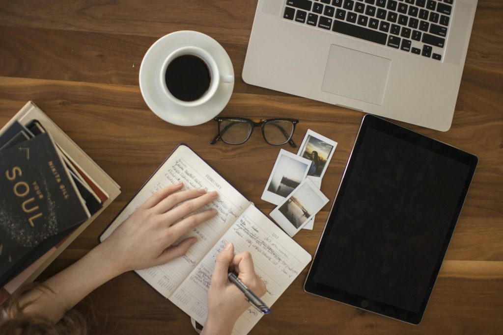 Person writing with a pen in a notebook