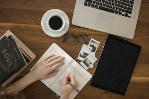 Person writing with a pen in a notebook
